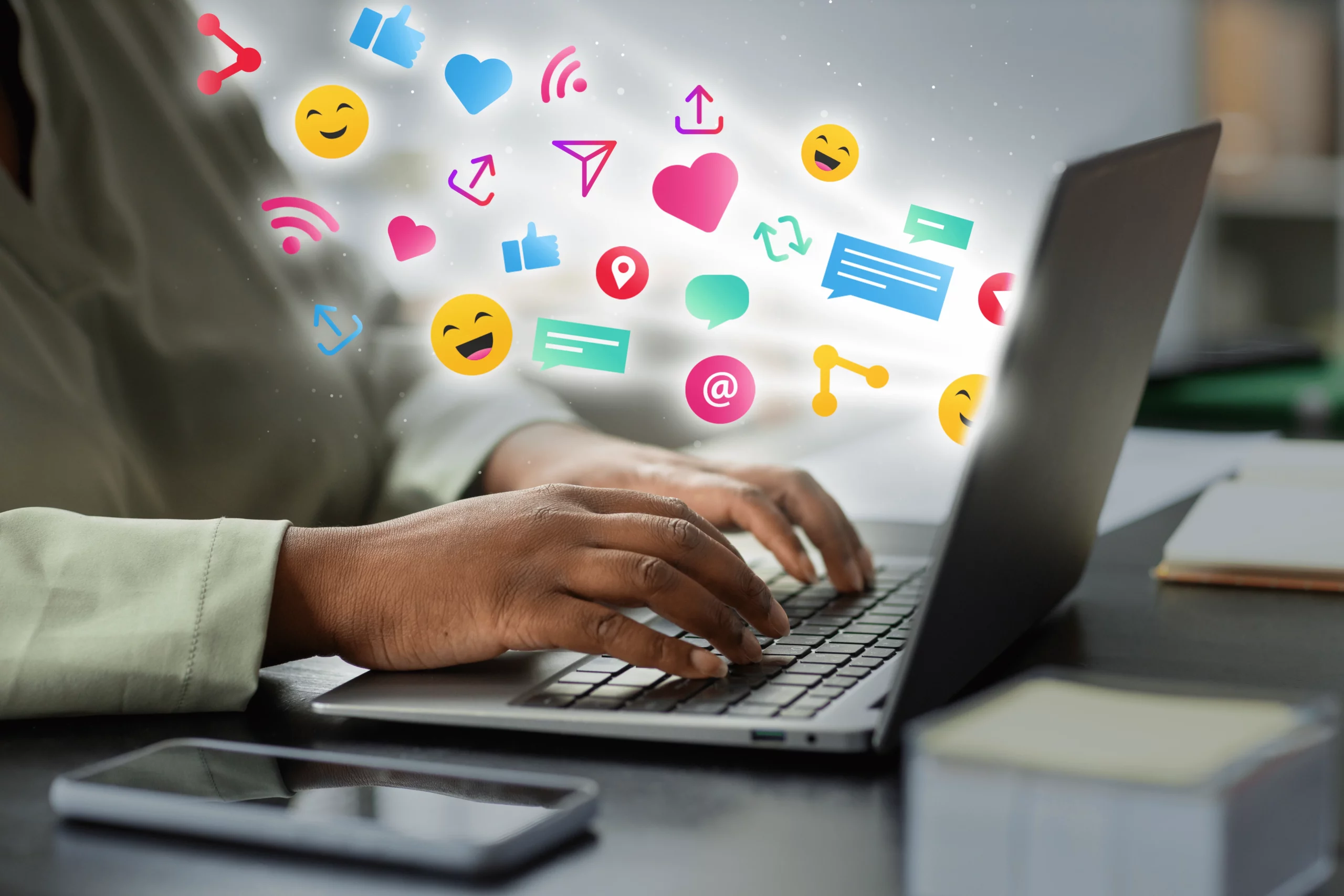 Person working on a laptop with social media engagement icons